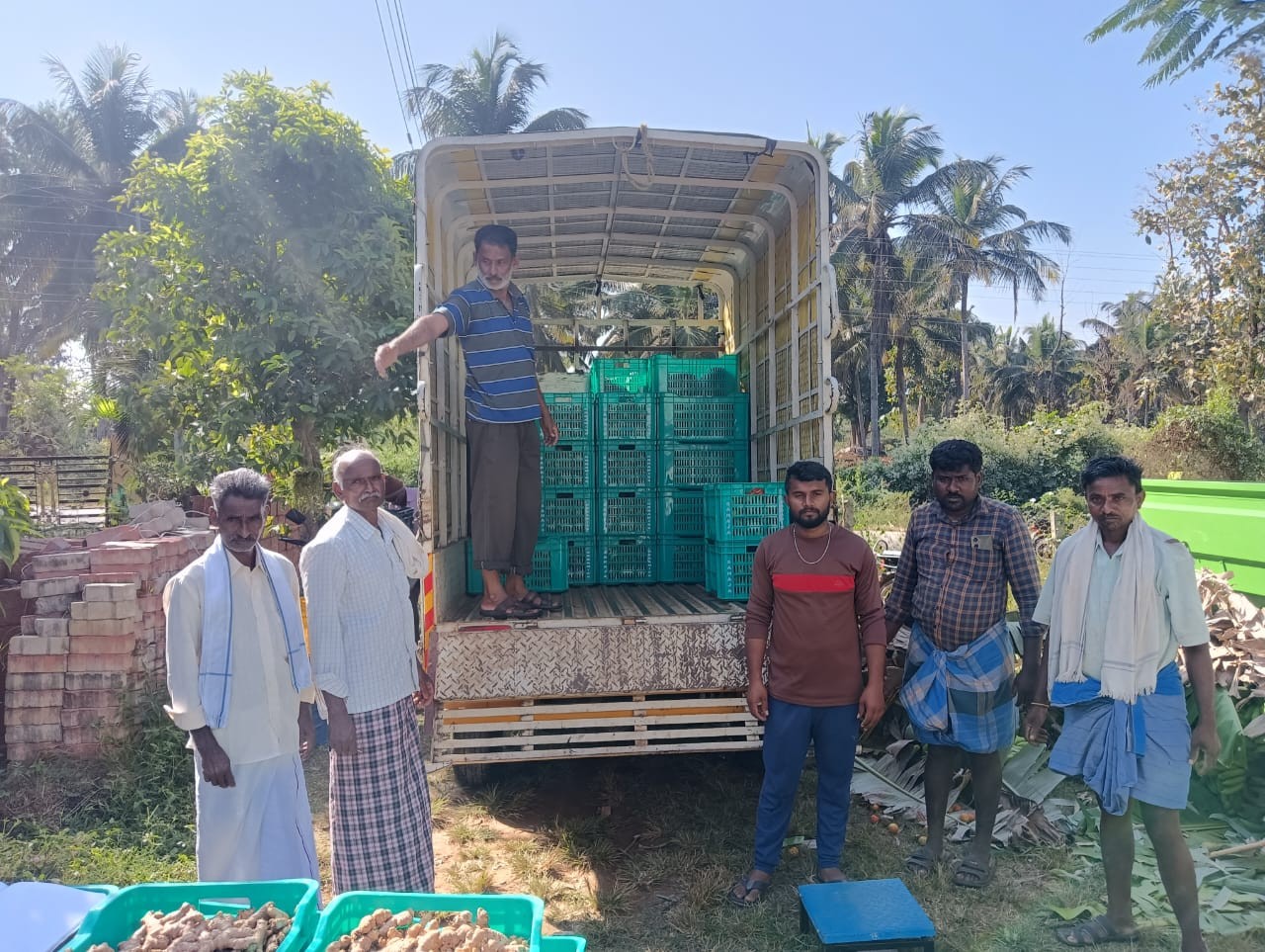 Farmers loading crates of vegetables onto a truck for Bangalore